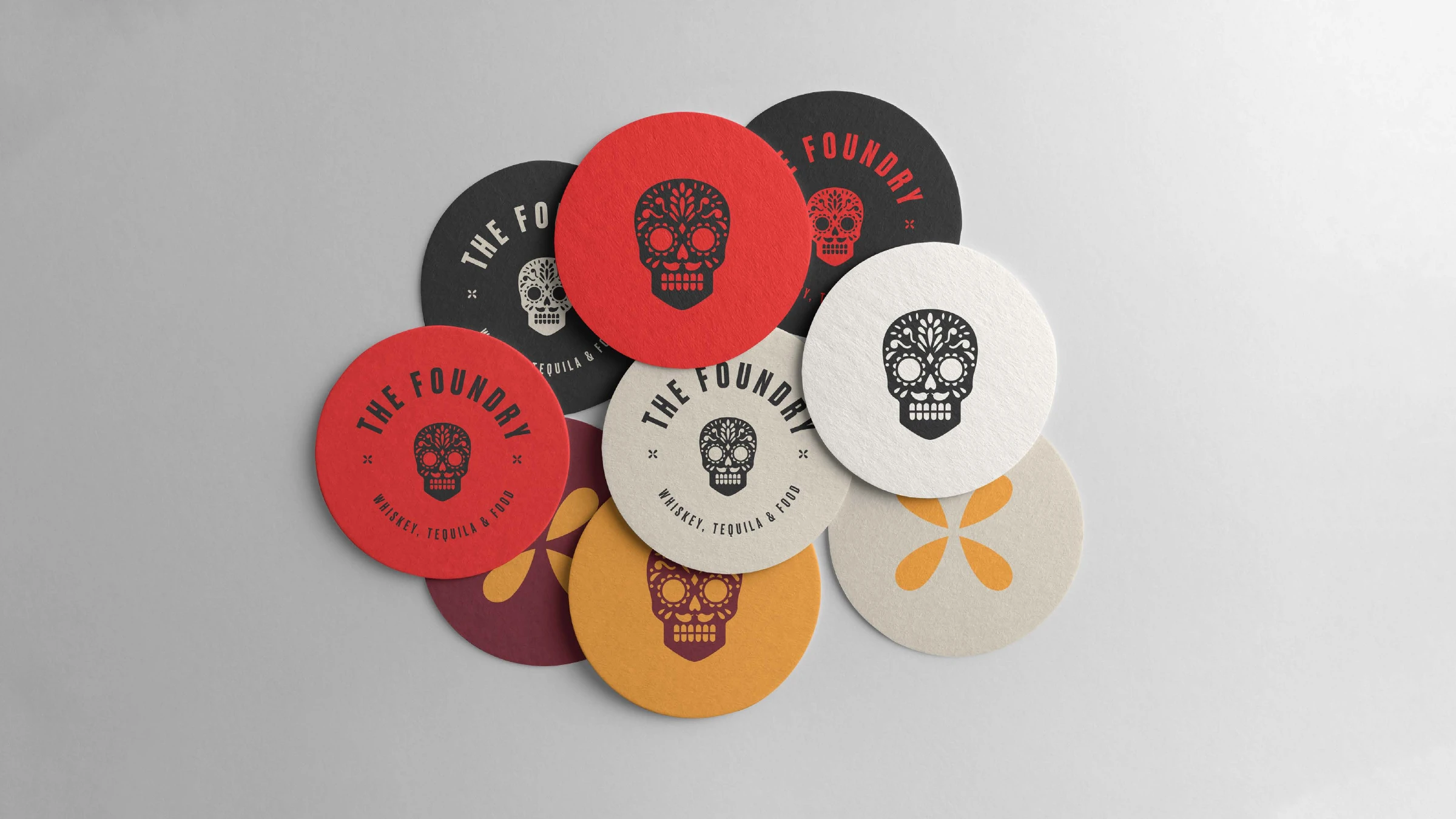 The Foundry beer coasters in red, black, cream, mustard and maroon with skull and badge marks
