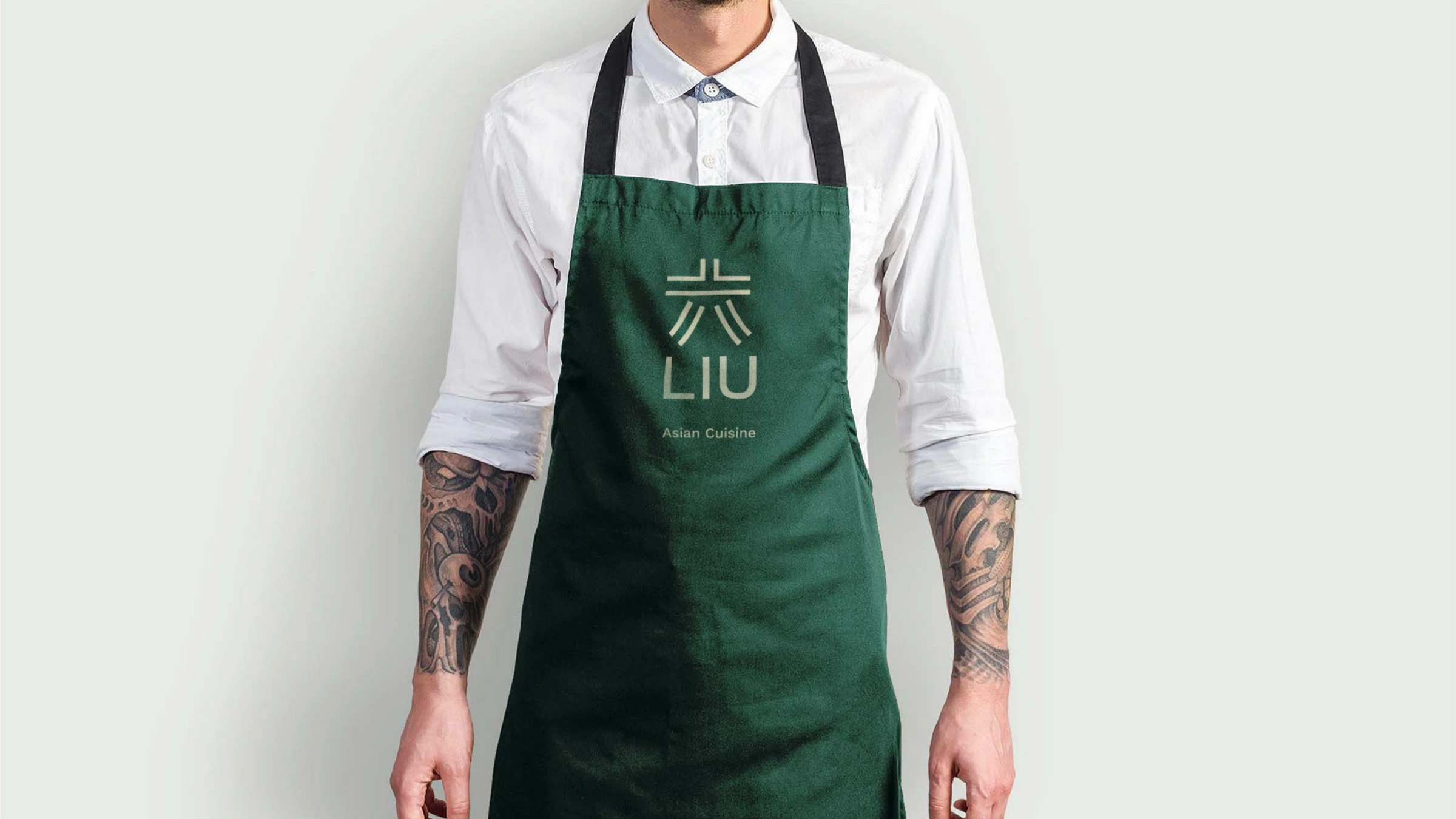 LIU green staff apron with the embossed logo
