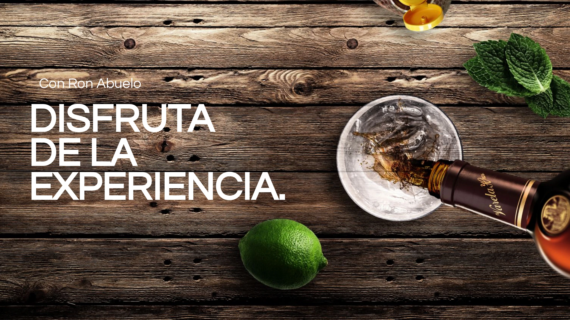 Ron Abuelo — 'Disfruta de la experiencia' over a rum pour with lime and mint on a dark wood surface